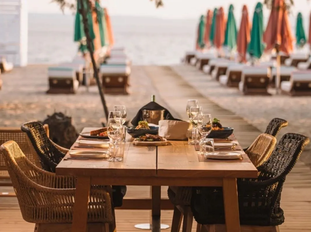 Gedeckter Restauranttisch direkt im Sand am Strand von Voula