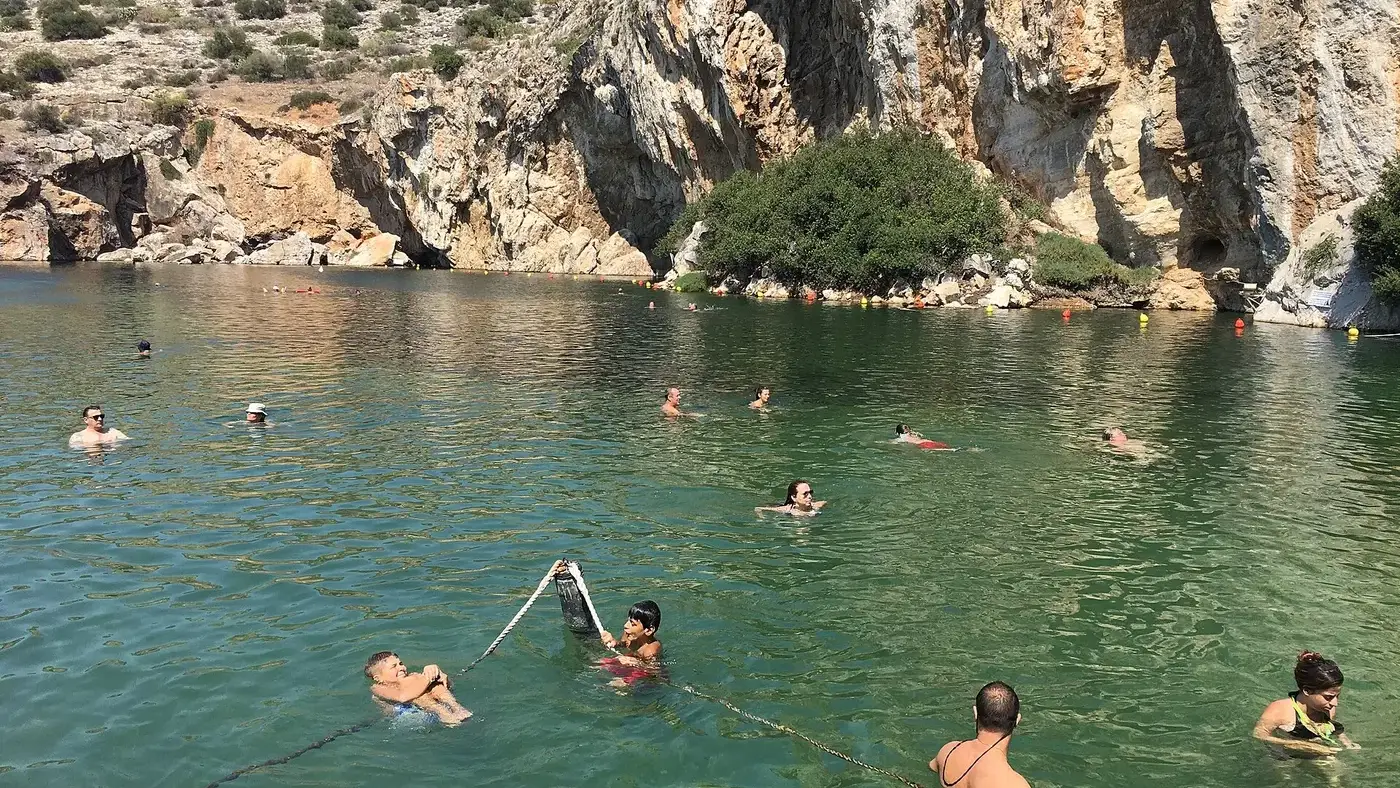 Η Λίμνη Βουλιαγμένης με τα γαλαζοπράσινα ιαματικά νερά κάτω από τον βράχο