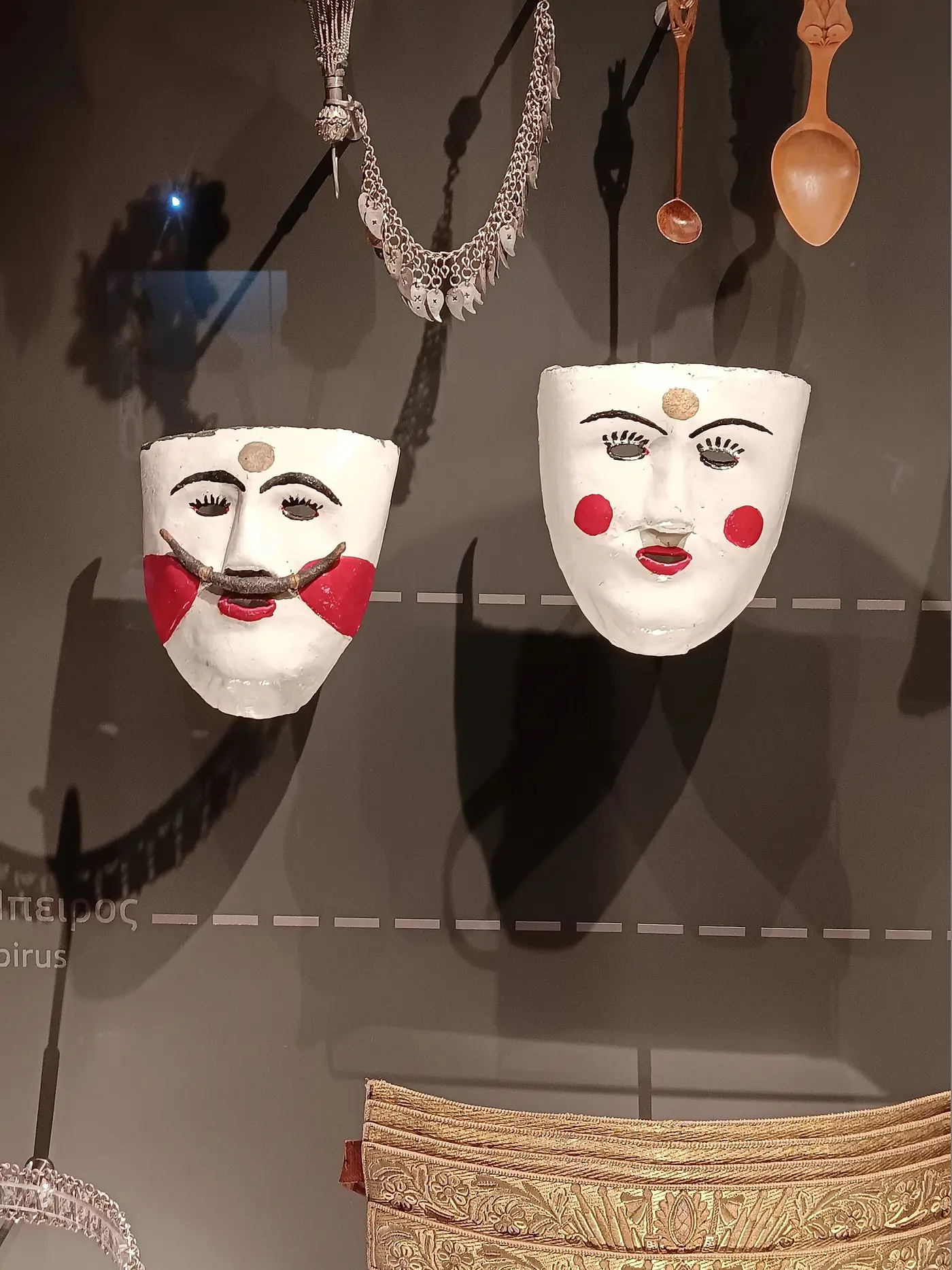 Deux masques de cire blancs aux joues rouges et moustaches noires, de la tradition Genitsaroi et Boules de Naoussa