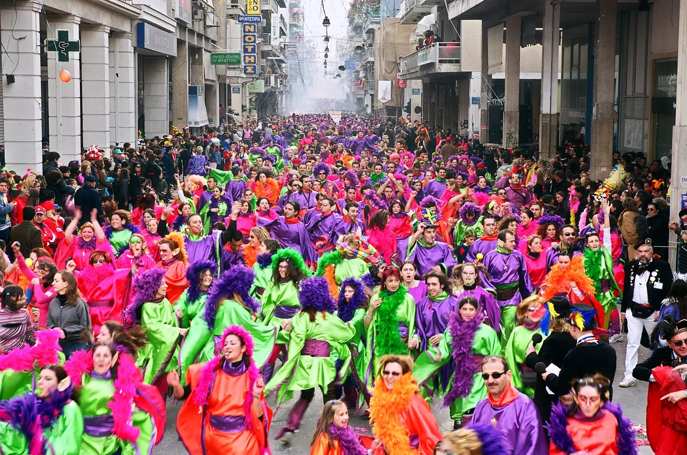Des milliers de carnavaliers en costumes violets, verts et roses remplissent une rue de Patras lors de la grande parade