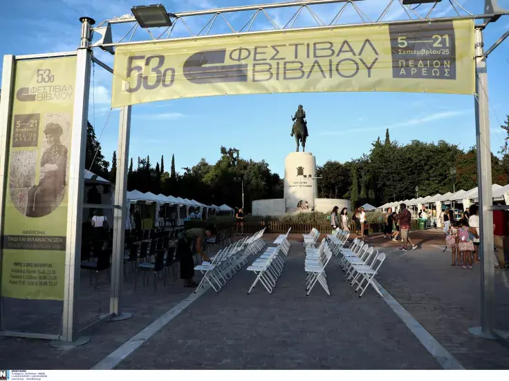 Η αψίδα εισόδου του 53ου Φεστιβάλ Βιβλίου στο Πεδίον του Άρεως, με καρέκλες για εκδηλώσεις και το έφιππο άγαλμα στο βάθος