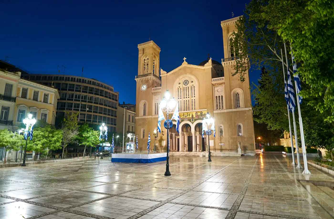 La place Mitropoleos à Athènes décorée pour Pâques, avec la cathédrale et ses clochers au fond au crépuscule