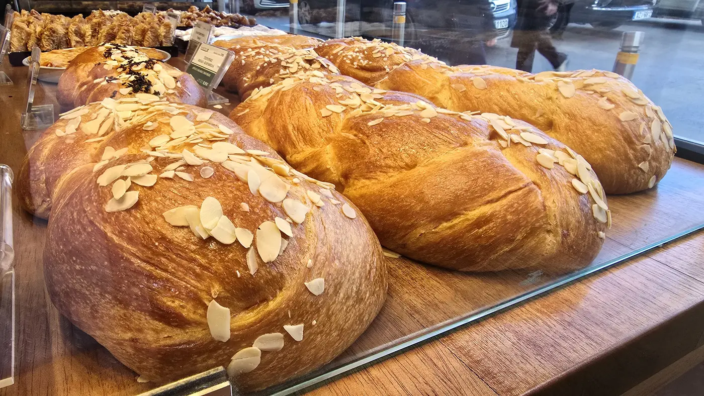 Des tresses de tsoureki aux amandes dans la vitrine d’une boulangerie d’Athènes