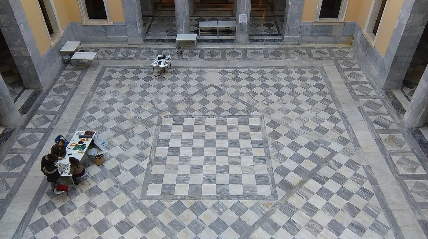 L’atrio dell’edificio Averof dall’alto, con un pavimento a mosaico di marmo a scacchiera