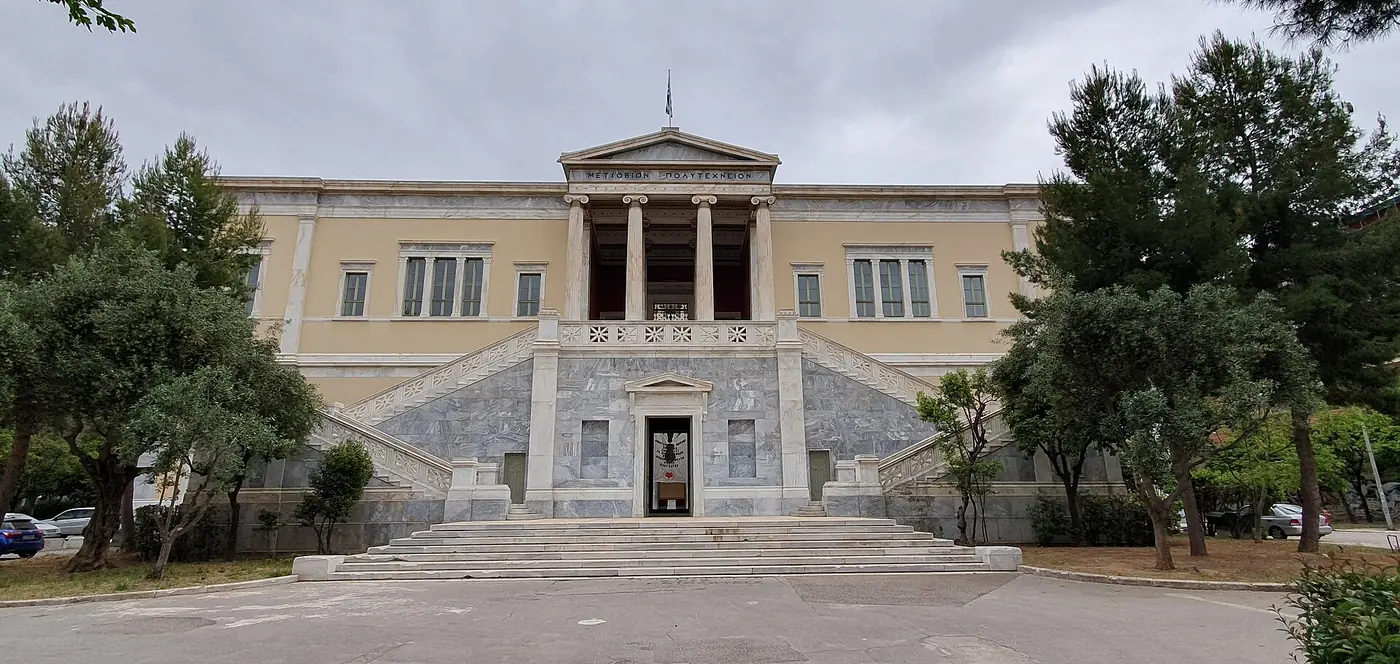 La facciata dell’edificio Averof al Politecnico con la scalinata di marmo e le colonne ioniche, tra i pini