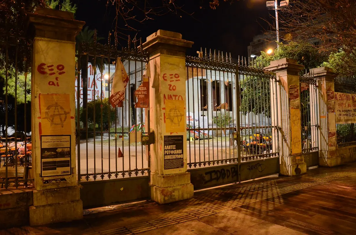 Il cancello principale del Politecnico la notte del 17 novembre, con slogan sui pilastri e i cancelli chiusi