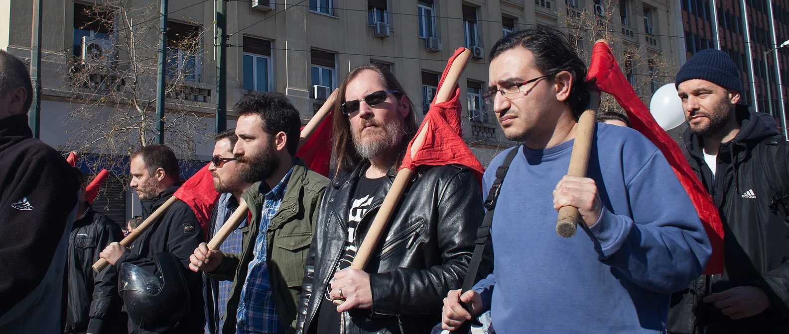 Синдикално шествие с червени знамена по улица „Панепистимиу“, между сградите в центъра