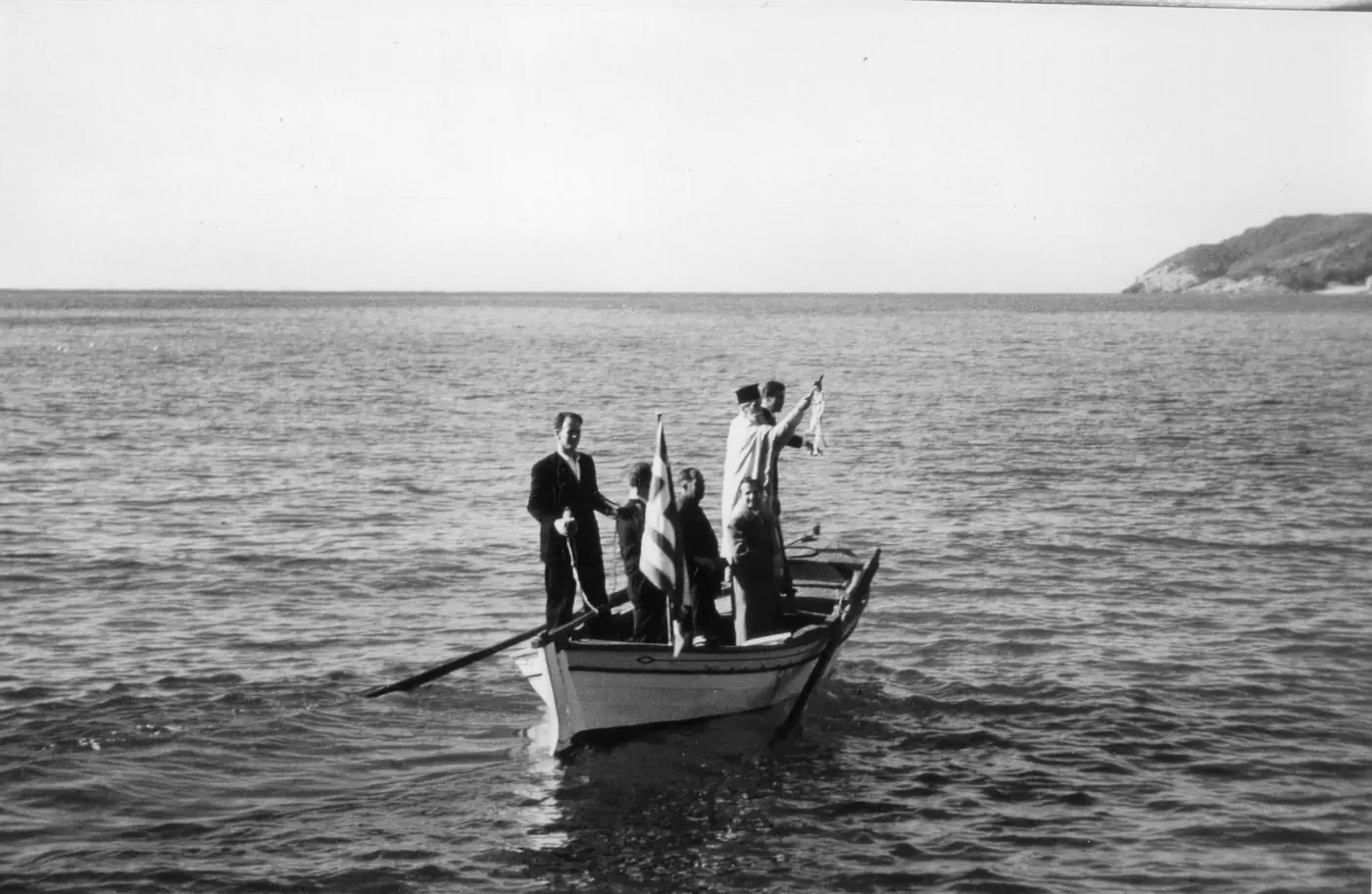 Черно-бяла снимка от 1959 г.: свещеник и лодкар в лодка в морето край Тасос се готвят да хвърлят кръста