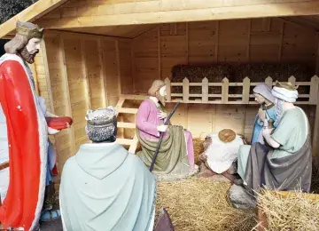 Kerststal met beelden van de geboorte van Christus in een houten stal met stro, met de drie koningen ervoor