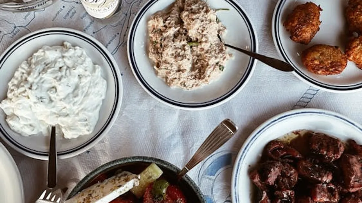 Πάνω από τραπέζι με ελληνικά μεζεδάκια: τζατζίκι, ταραμοσαλάτα, σαλάτα και κεφτεδάκια