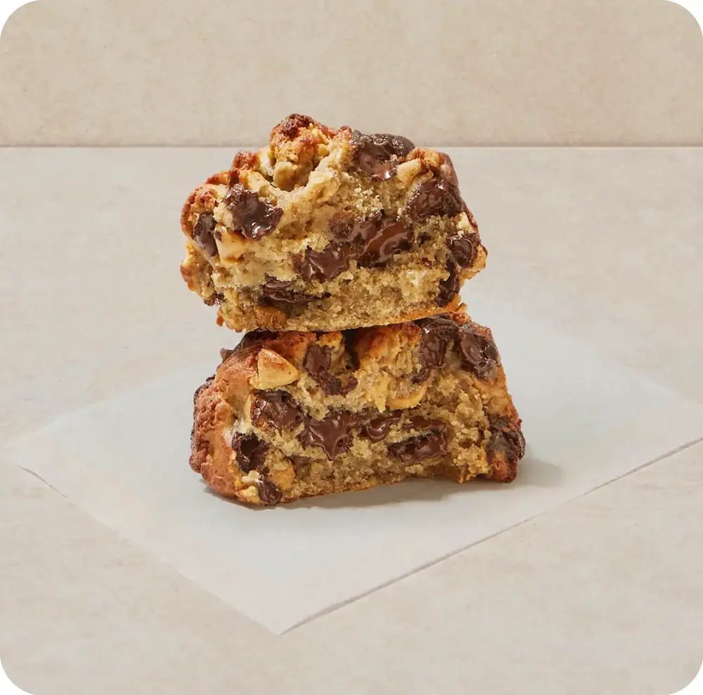 Protein Cookie: δύο μπισκότα με κομμάτια σοκολάτας πάνω σε λαδόχαρτο