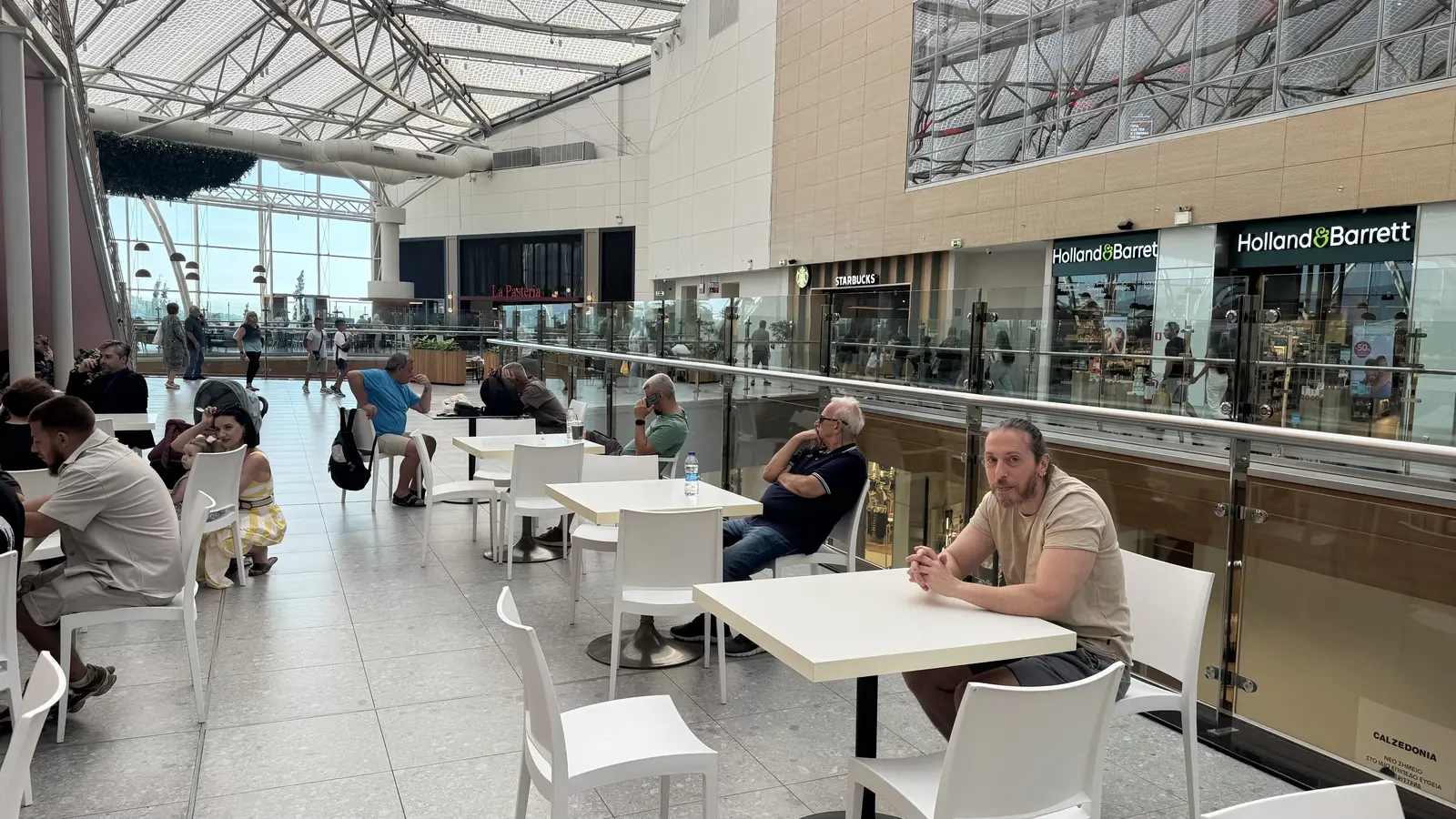 Restauracje w The Mall Athens: stoliki, szyldy i odwiedzający w porze posiłków