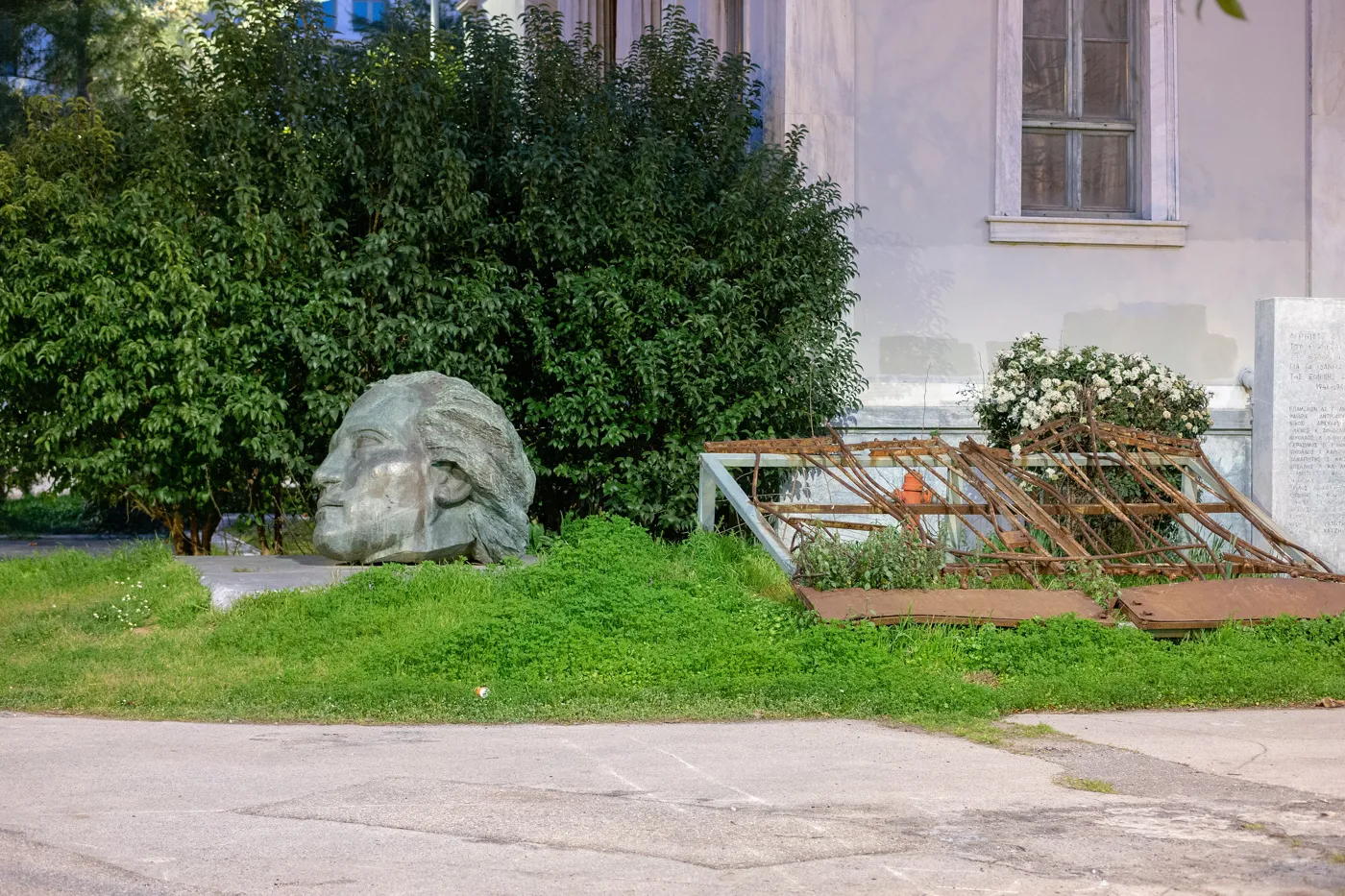 理工学院庭院草地上的雕塑头像和旧铁门