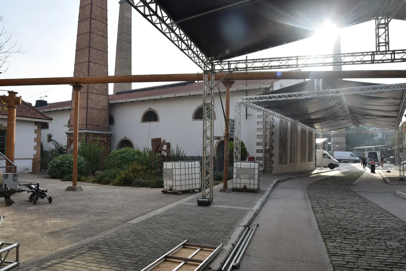 Technopolis 院子里的金属顶棚和烟囱，旁边是工厂的石头建筑