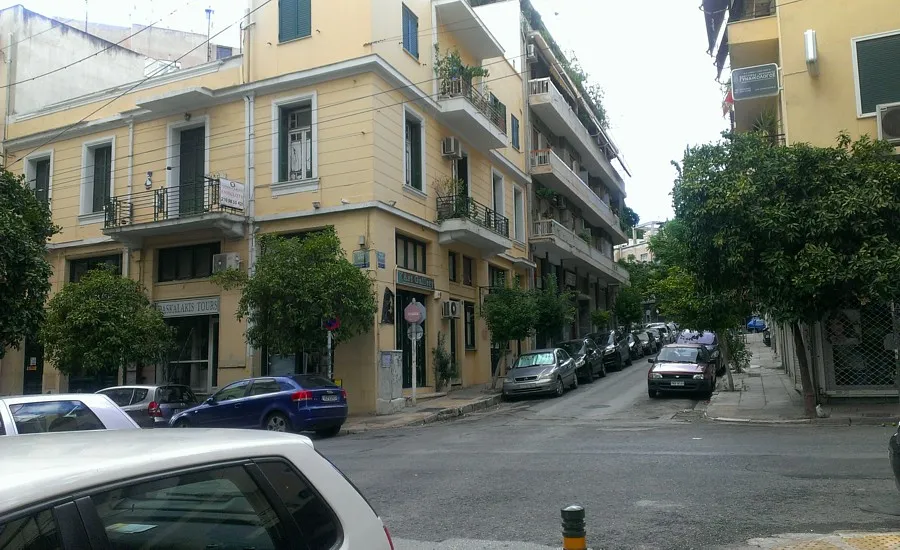 库卡基一条下坡的街道，公寓楼、树木和停着的汽车