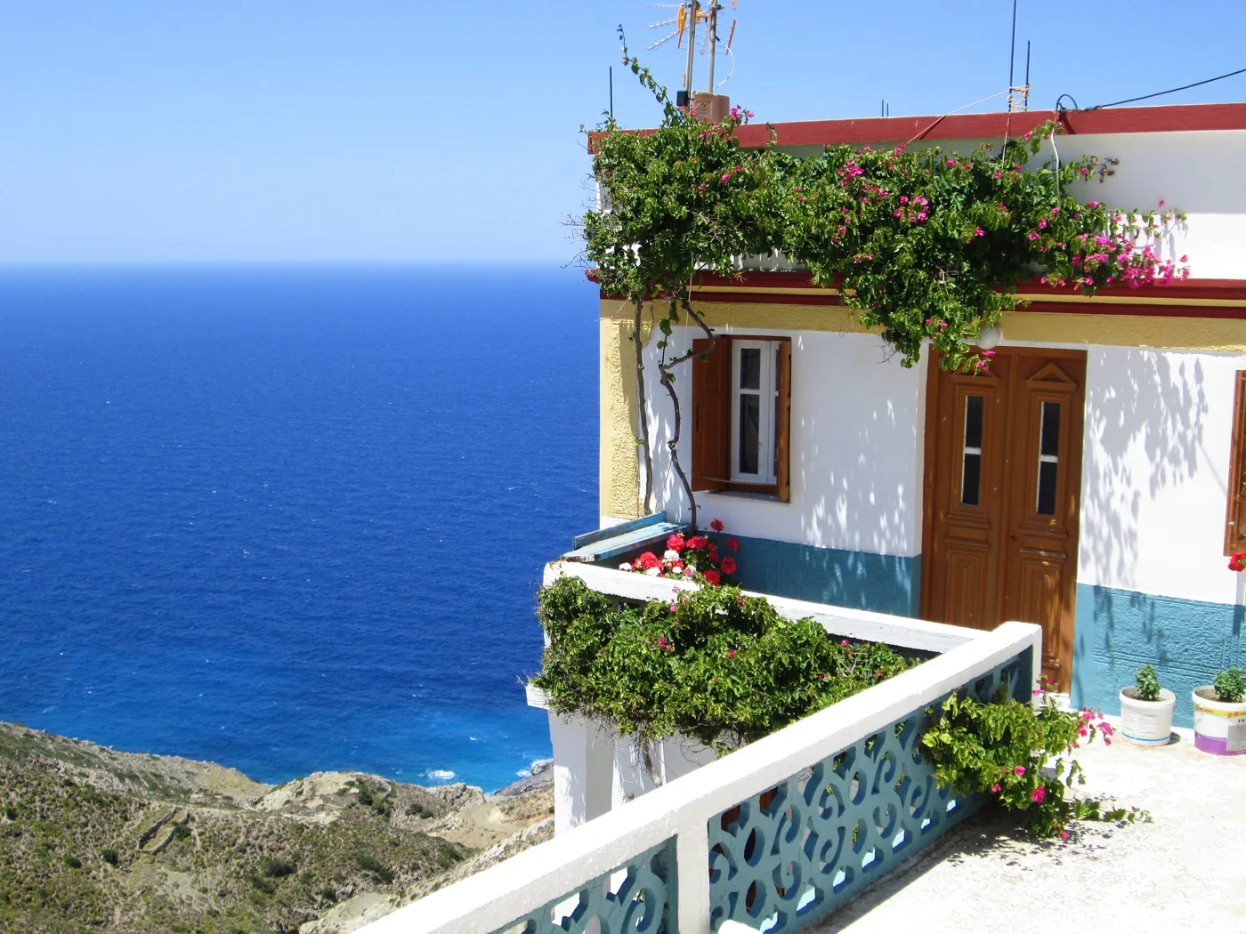 Un balcon fleuri à Olympos, au-dessus de la mer bleu profond