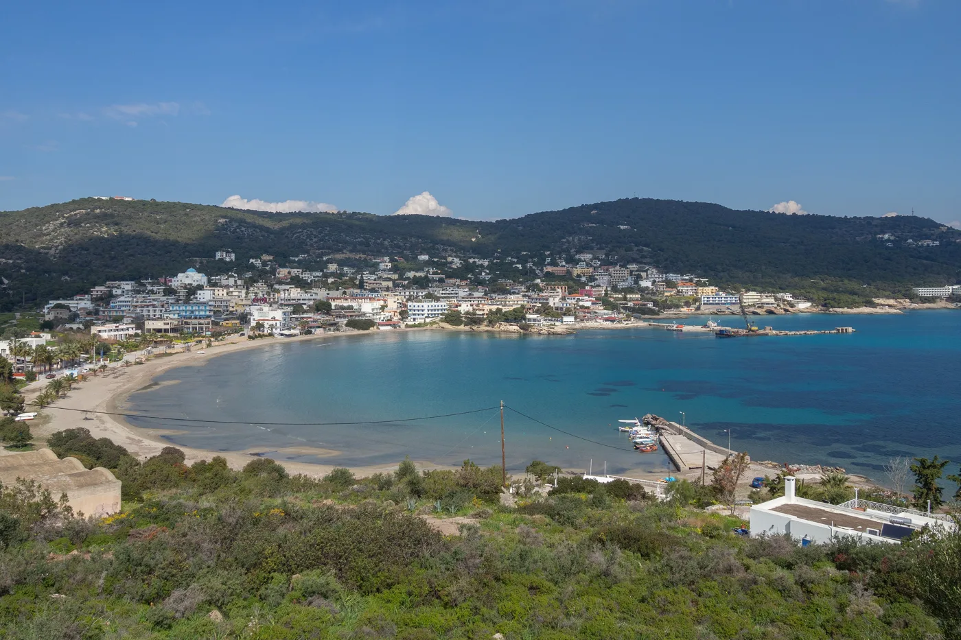 A baía de Agia Marina com uma longa praia de areia e casas na colina