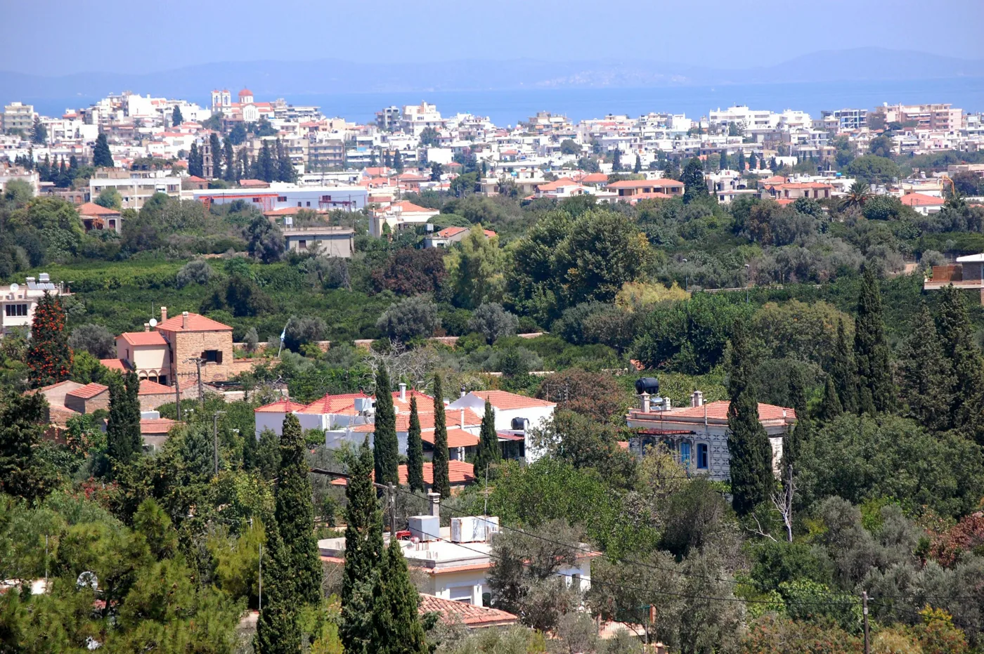 Miasto Chios z góry, z ogrodami, cyprysami i morzem w tle