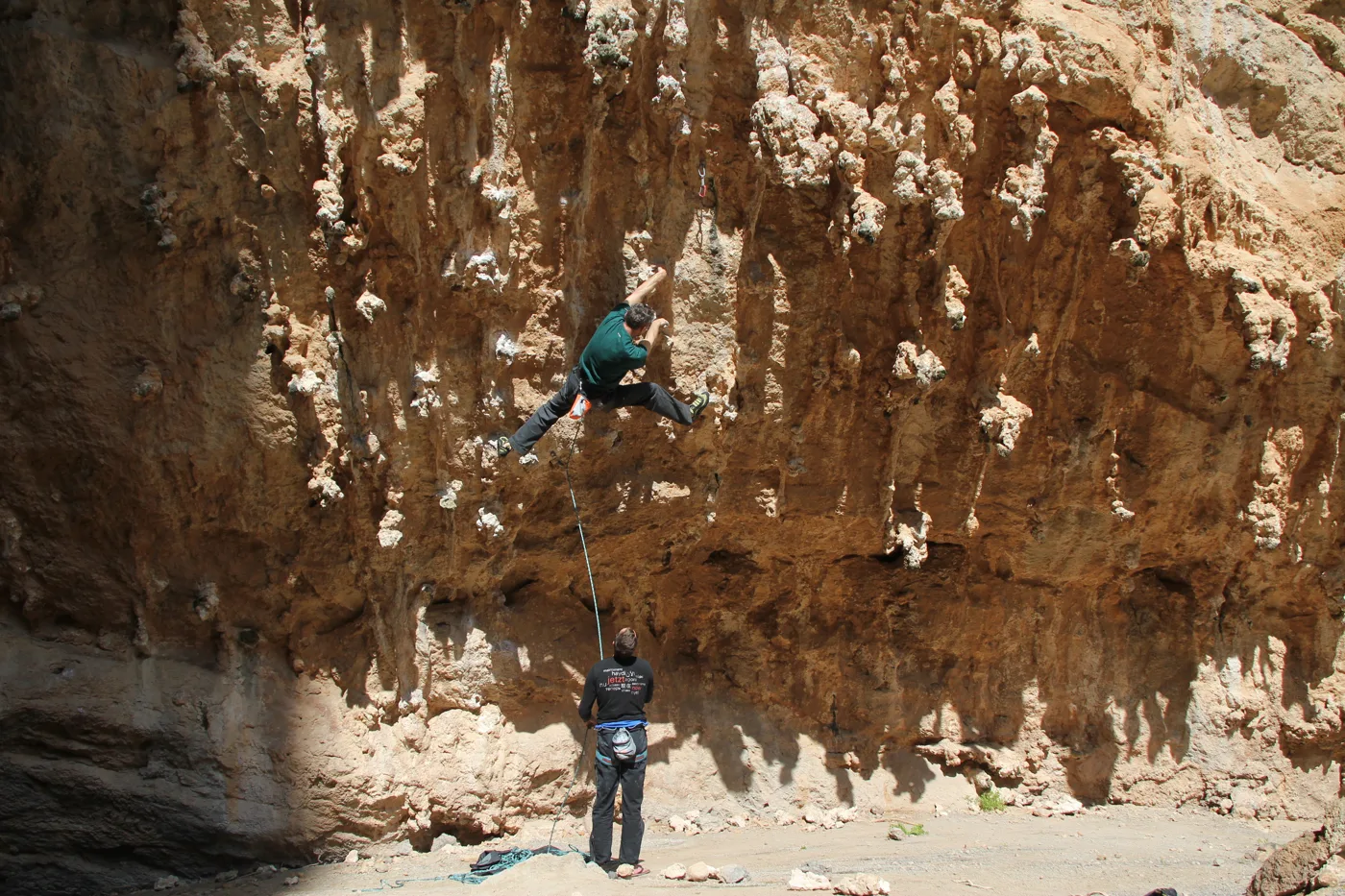 Escaladores en una enorme cueva de roca naranja