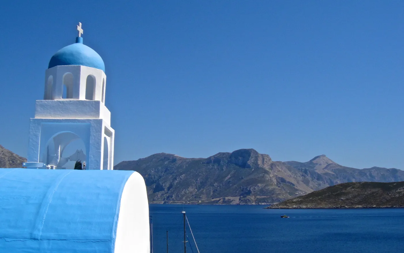 Una iglesia blanca de cúpula azul en Emporios, con vistas al mar