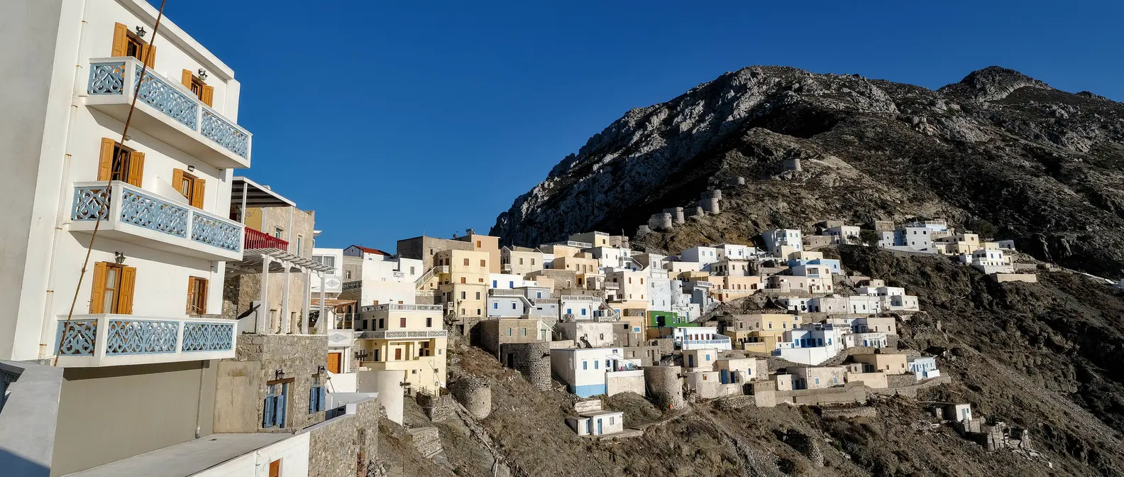 Olympos à Karpathos, avec des maisons colorées accrochées à la pente et des moulins sur la crête