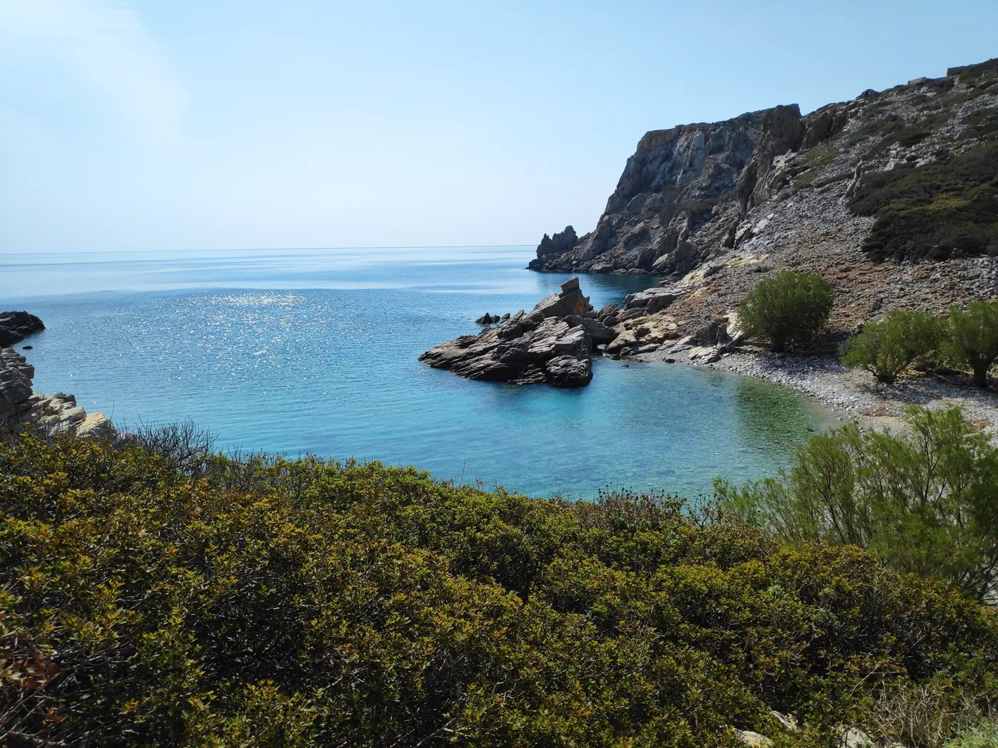 Une crique à l’eau bleue avec des rochers à Saria