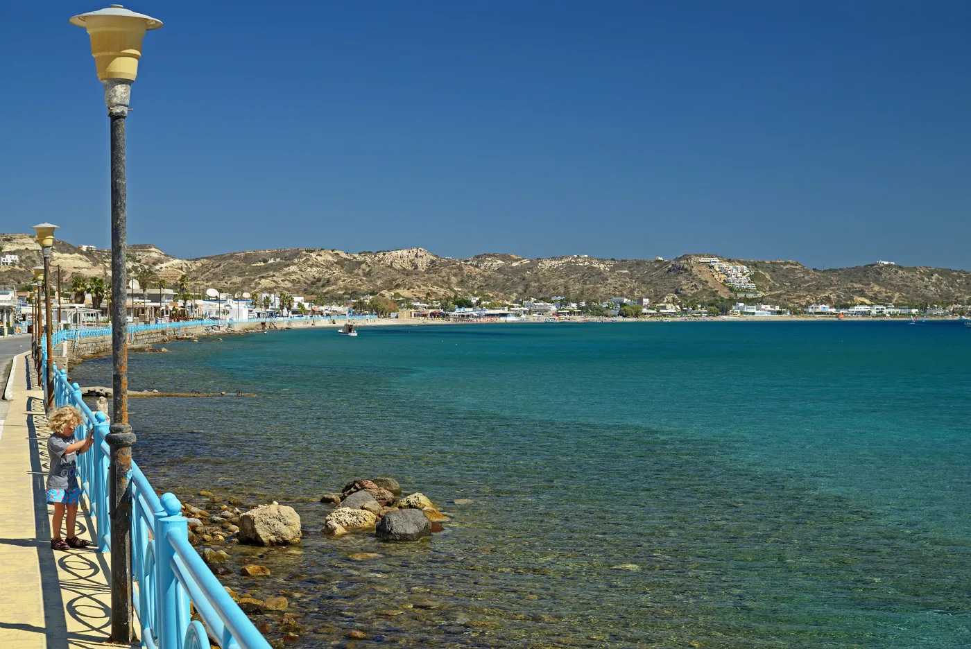 La lunga spiaggia di sabbia di Kefalos vista da Kamari, con acqua azzurra e colline