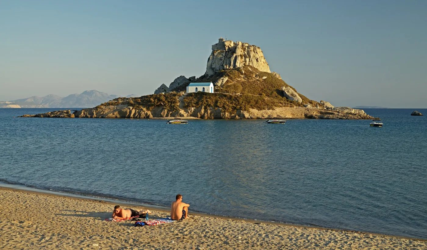 L’isolotto di Kastri con la sua chiesetta bianca, di fronte alla spiaggia di sabbia di Kefalos