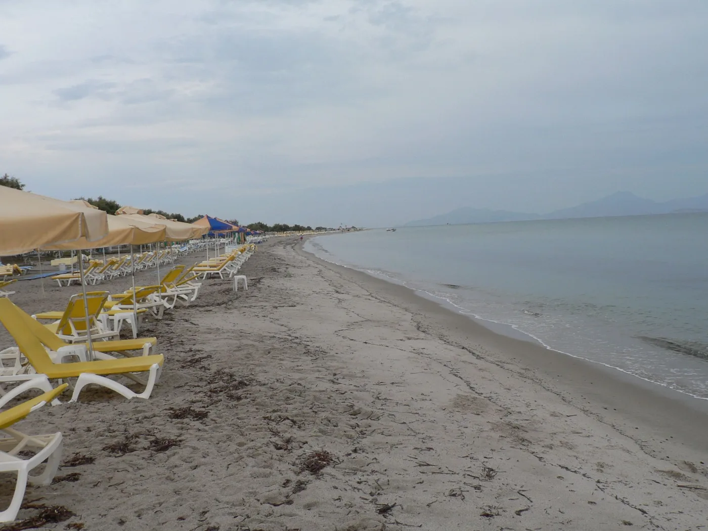 La lunga spiaggia di sabbia di Tigaki con lettini e acqua bassa