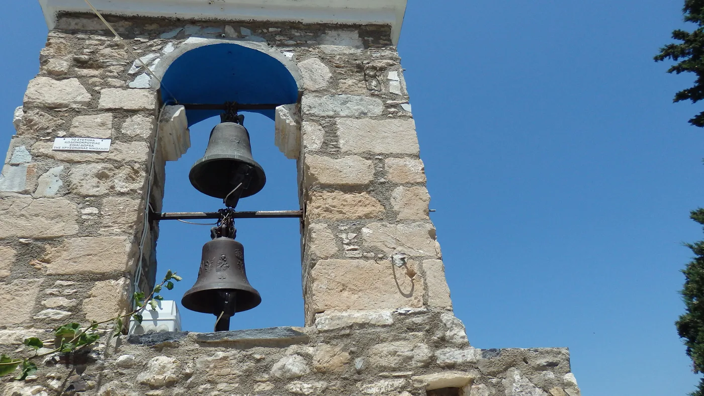 Un campanile di pietra con due campane a Zia sotto il cielo azzurro
