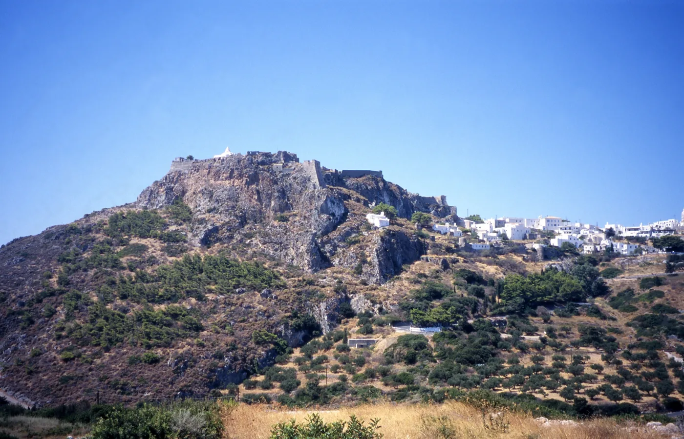 Le Château de Chora sur le rocher, avec des oliviers et les maisons en dessous