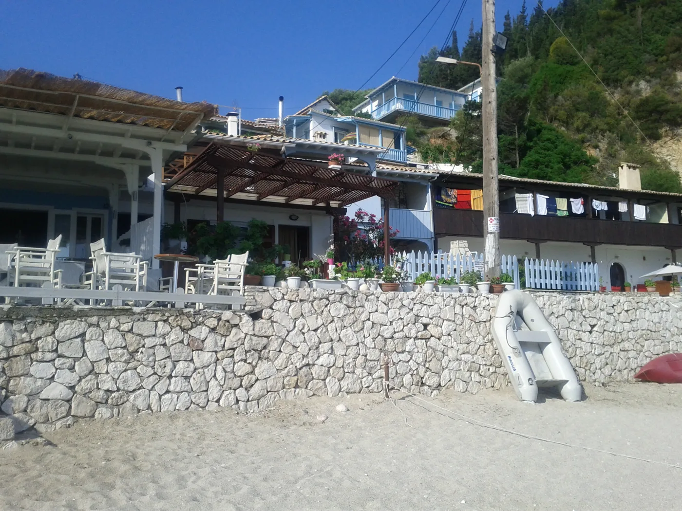 Des tavernes avec un mur de pierre, directement sur la plage d’Agios Nikitas