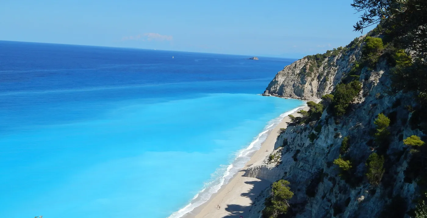 La longue plage d’Egremni vue d’en haut, avec une eau bleue sous des falaises vertes