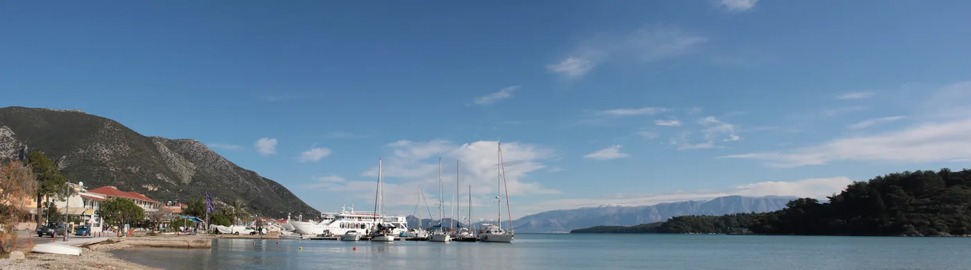 Le port de Nydri avec des voiliers, des montagnes et des îlots en face