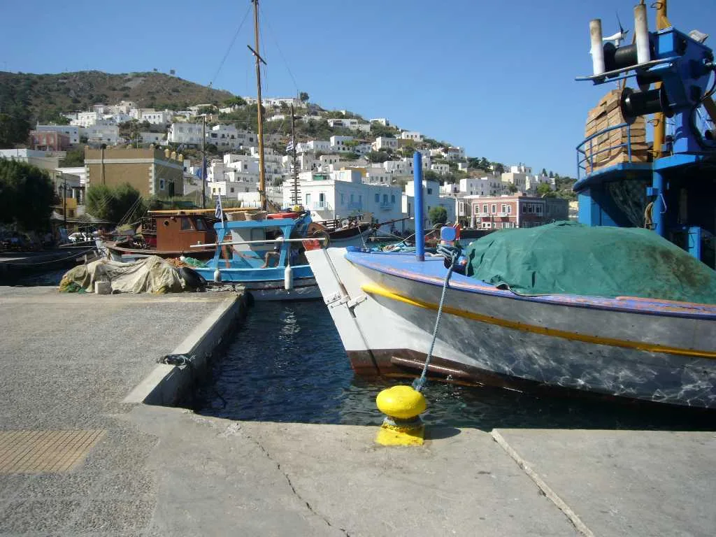 Barche da pesca ormeggiate nel porto di Agia Marina, con case colorate dietro