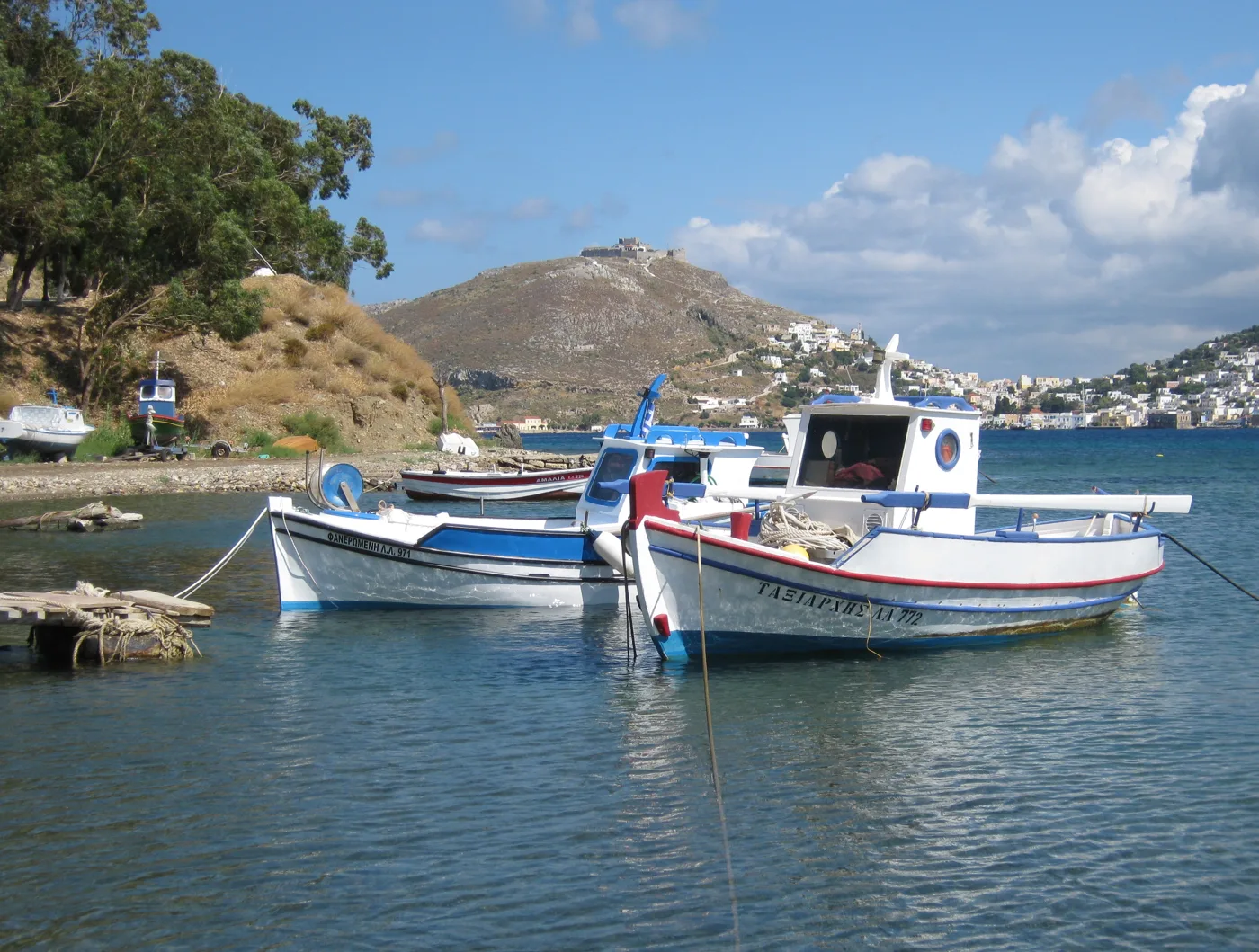 Una barca da pesca ad Alinda, con colline e il Castello in lontananza