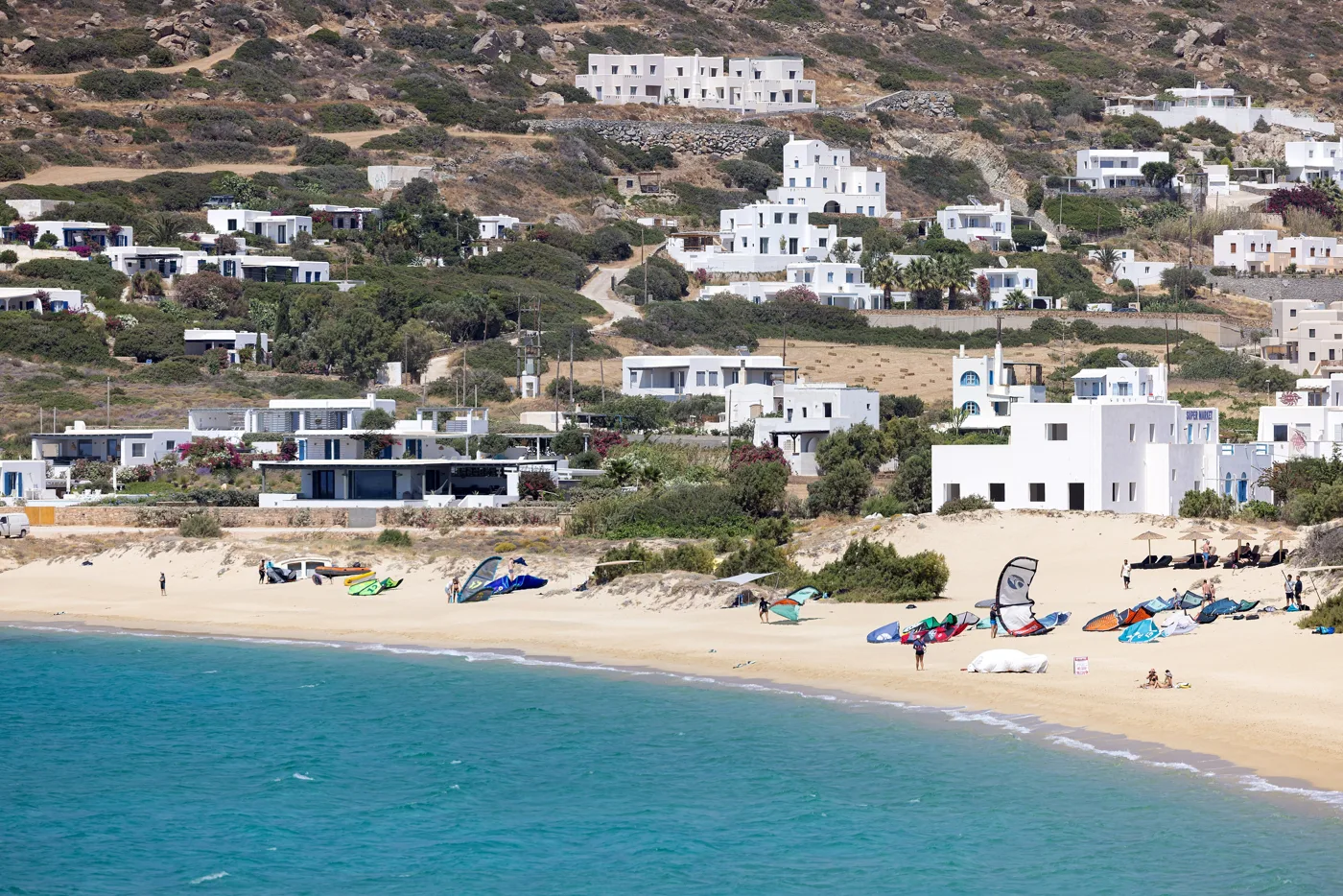 Η Μικρή Βίγλα με λευκά σπίτια στον λόφο και πανιά του kitesurf στην αμμουδιά