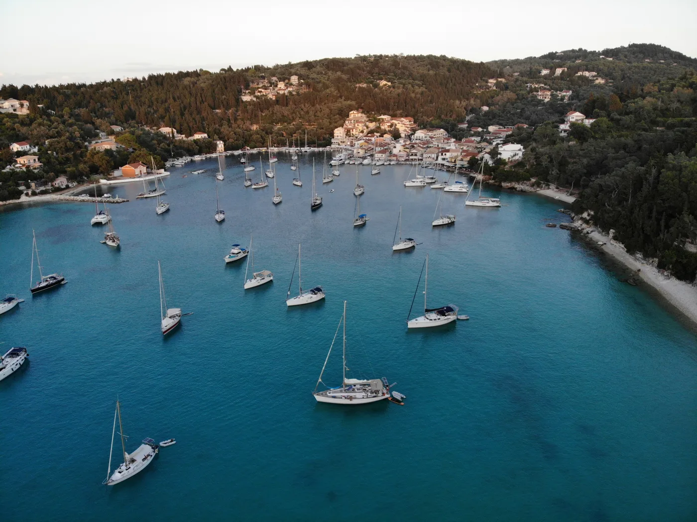 La baia di Lakka con barche a vela e il villaggio sullo sfondo