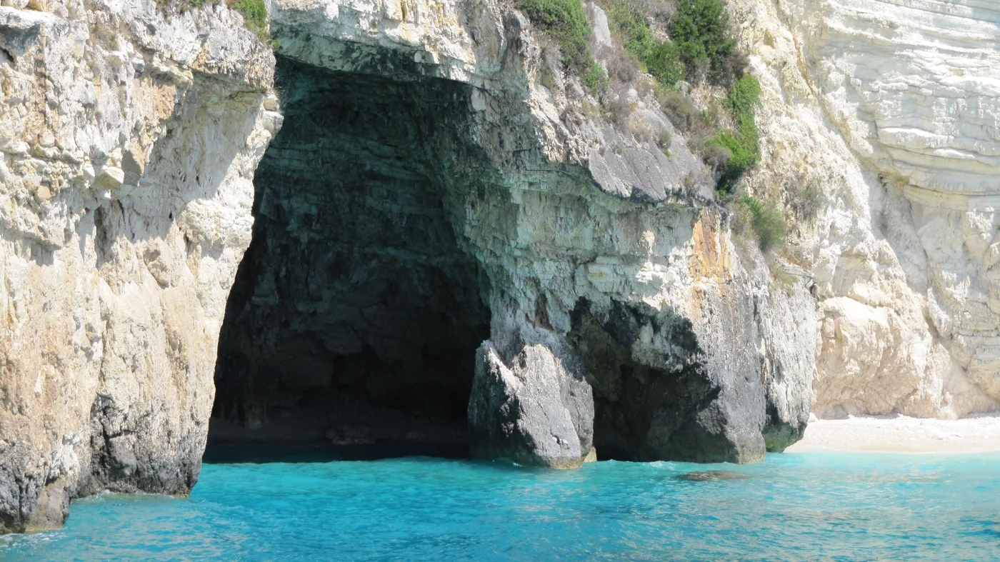Una grande grotta marina in scogliere bianche, con acqua azzurra