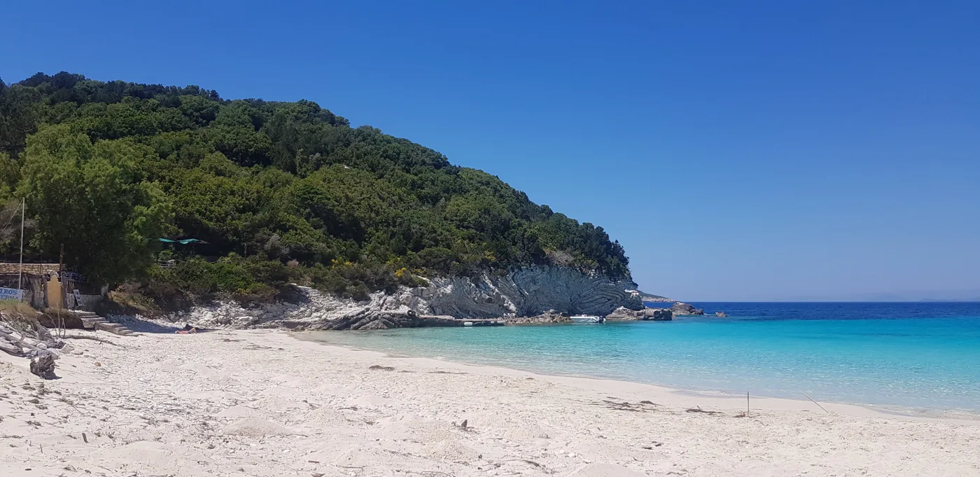 Vrika con la sabbia bianca e la collina coperta di pini