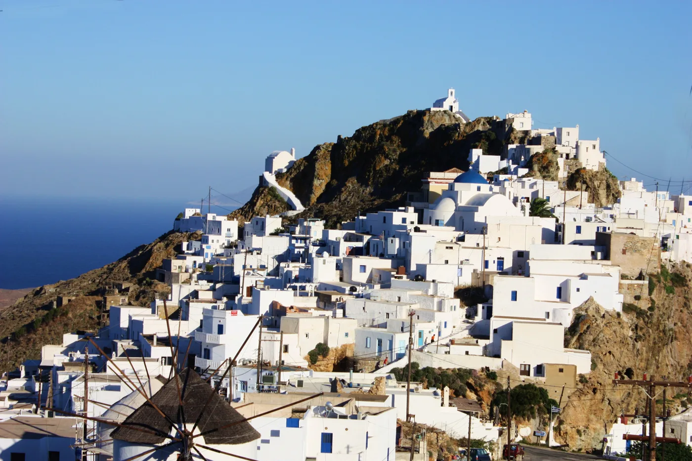 Η Χώρα της Σερίφου από μακριά, λευκά σπίτια σε έναν κωνικό λόφο με το Κάστρο στην κορυφή