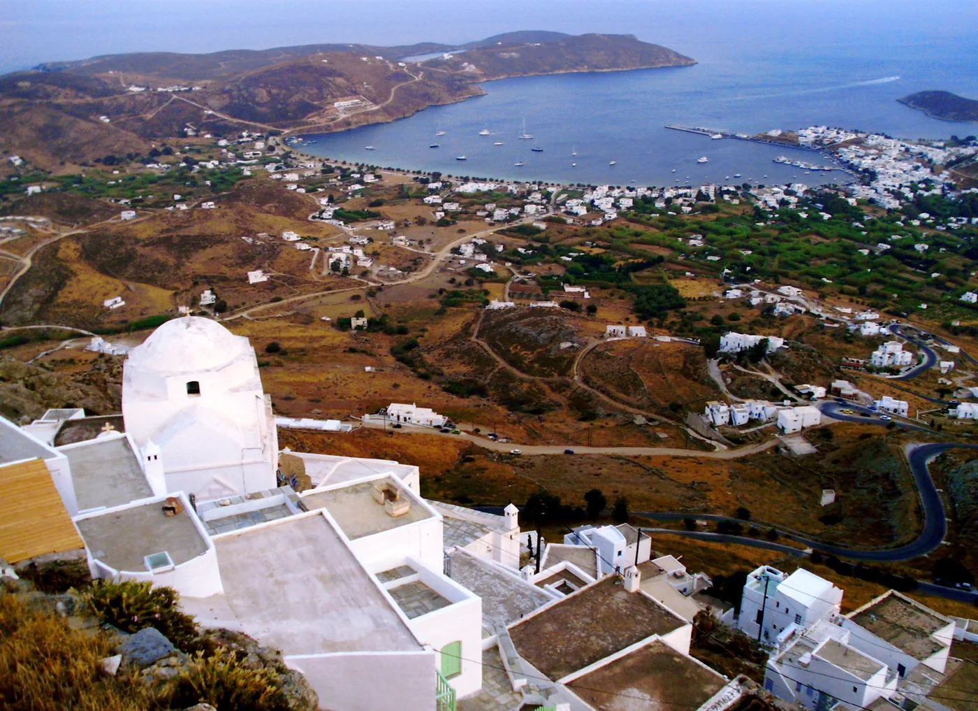 Η Χώρα και ο κόλπος του Λιβαδιού από ψηλά, με τον λευκό τρούλο μιας εκκλησίας μπροστά