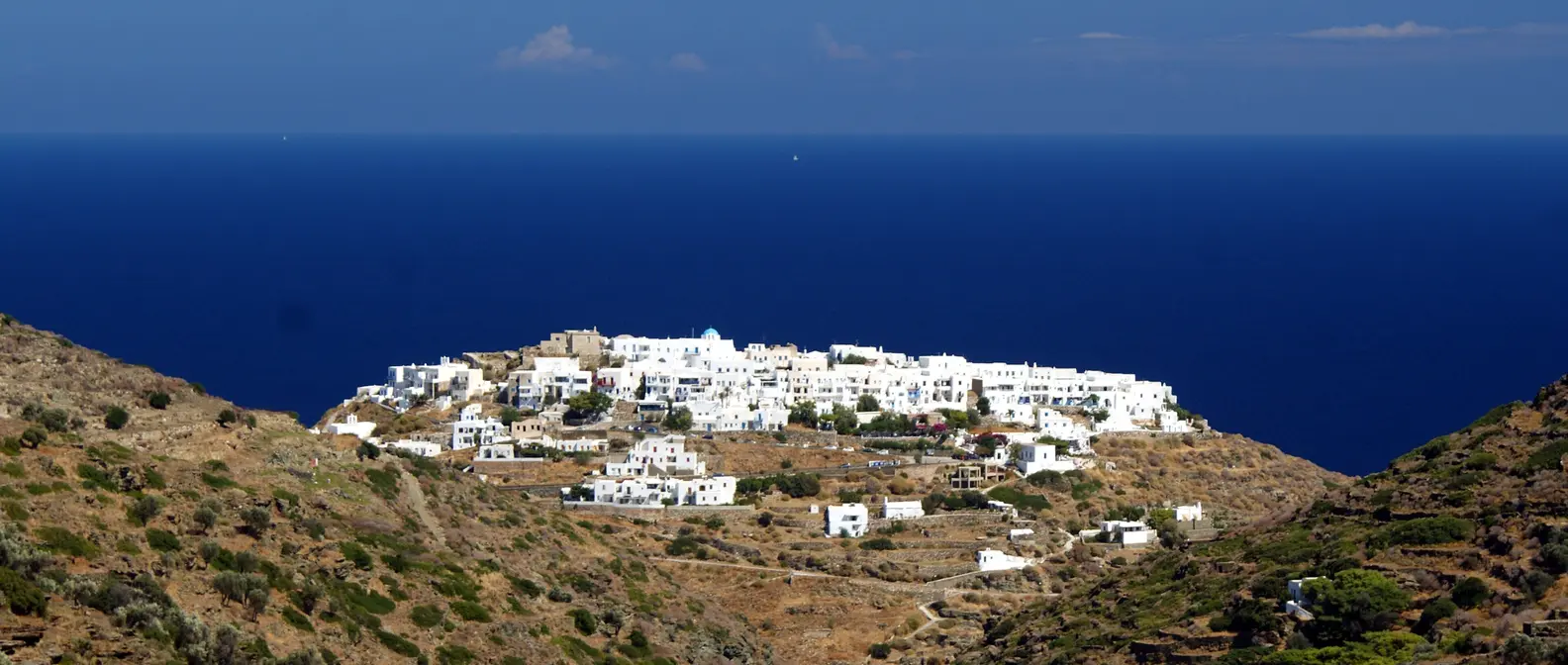 Kastro auf Sifnos, weiße Häuser auf einem Hügel, dahinter die tiefblaue Ägäis