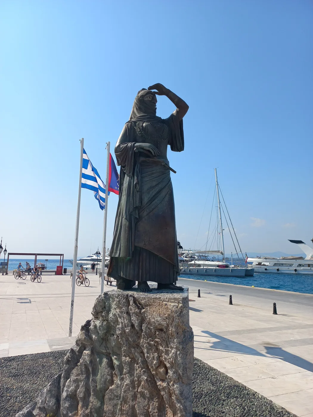 Το άγαλμα της Μπουμπουλίνας στο λιμάνι, με ελληνική σημαία δίπλα