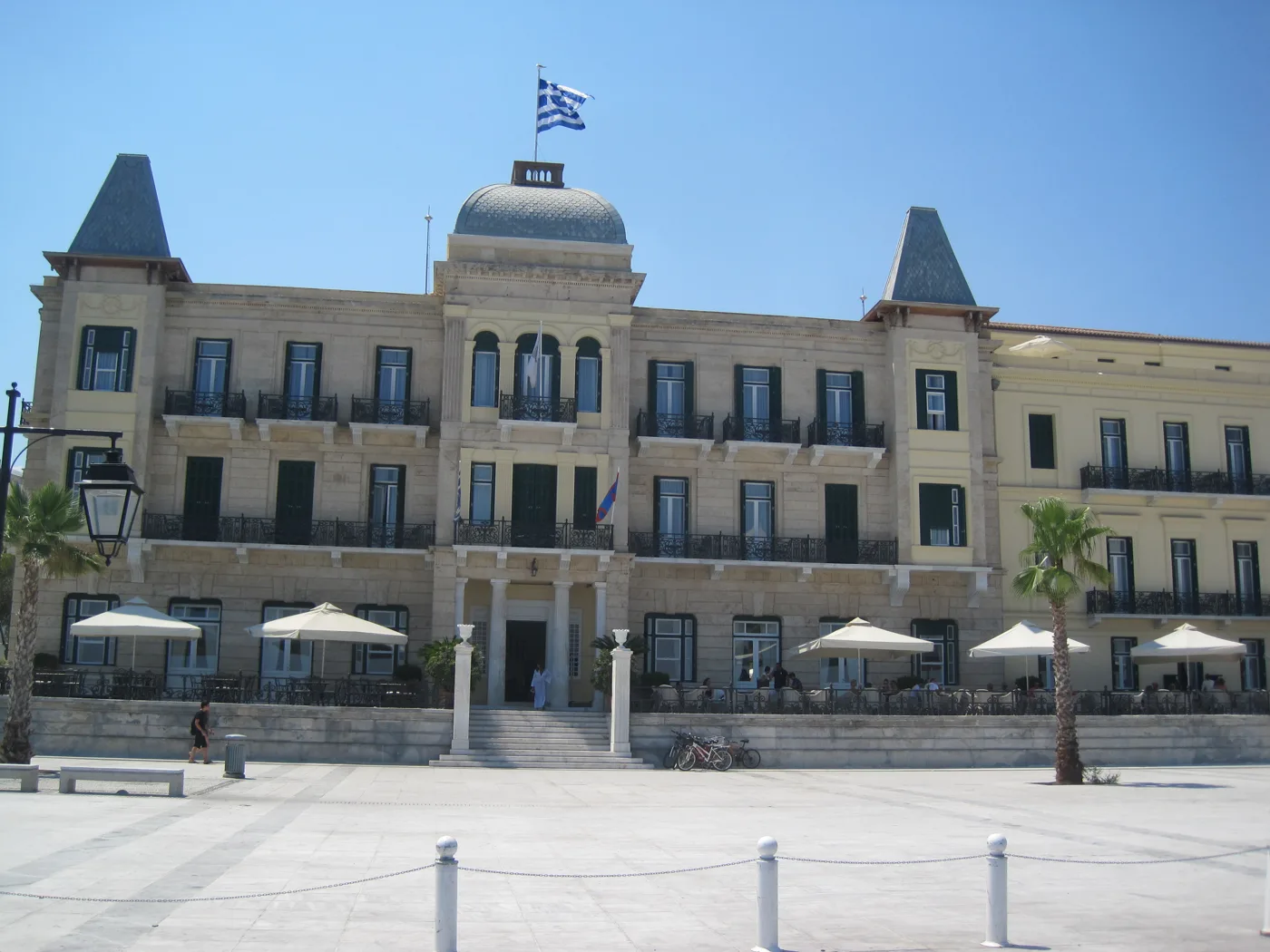 Η πρόσοψη του Ποσειδωνίου με τους δύο πύργους και φοίνικες μπροστά
