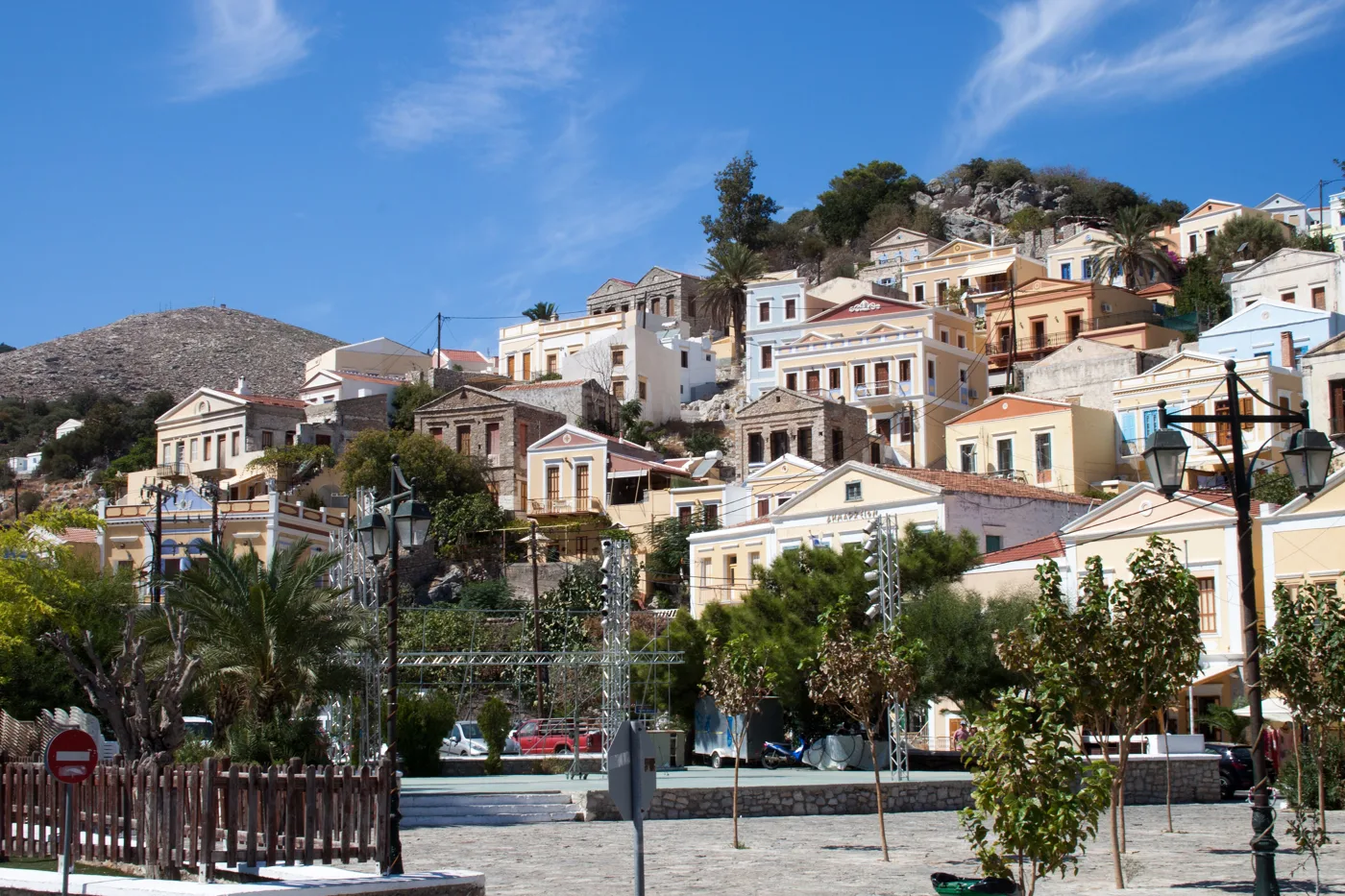 Case neoclassiche dai colori tenui salgono sul pendio sopra la piazza di Gialos