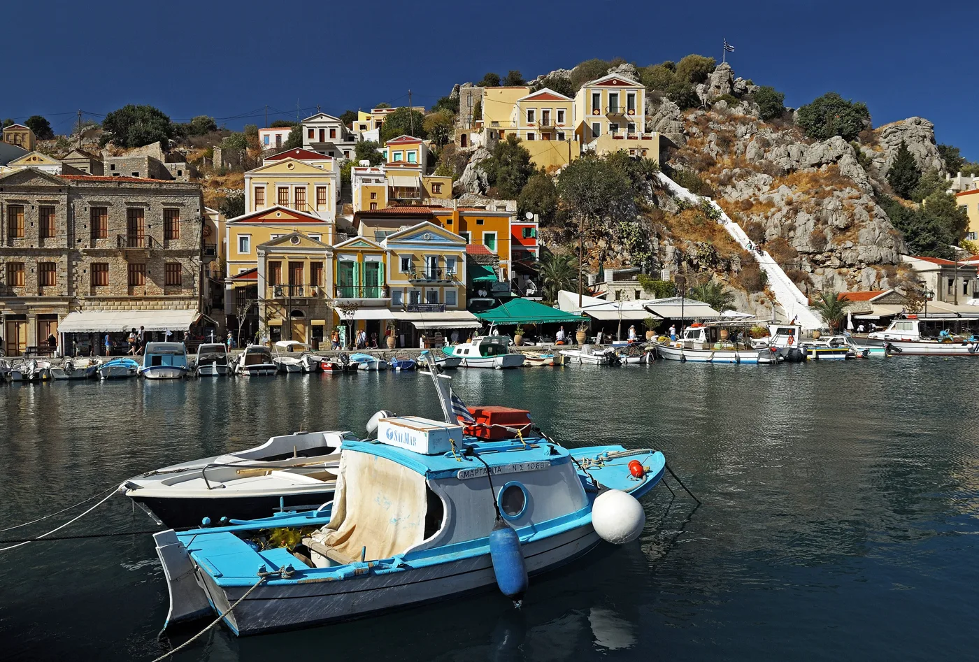 Barche da pesca nel porto di Symi, davanti a case colorate