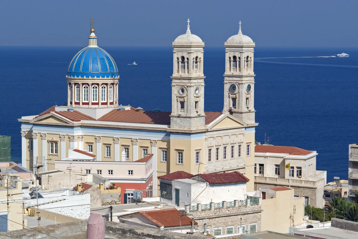 Agios Nikolaos avec sa coupole bleue et ses deux clochers, la mer derrière