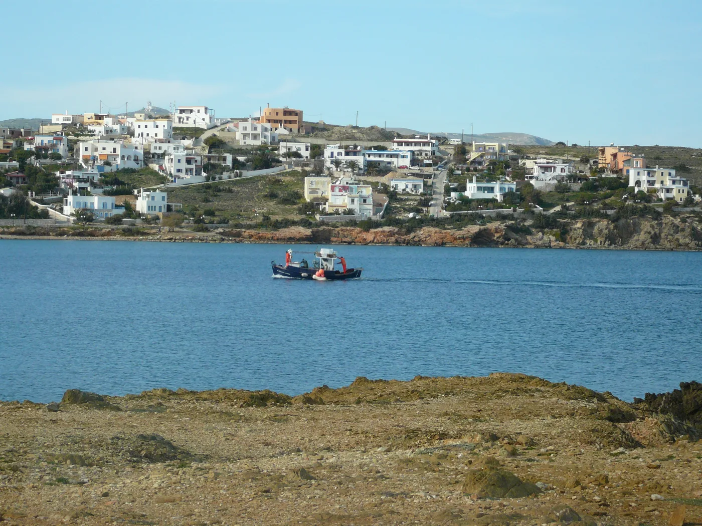 Azolimnos avec des maisons blanches sur la colline et un bateau sur la mer