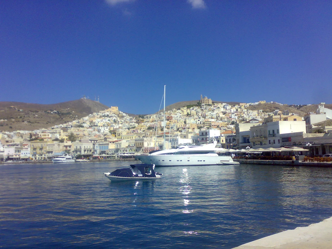 Ermoupoli vue du port, avec les maisons qui montent sur deux collines et des yachts devant